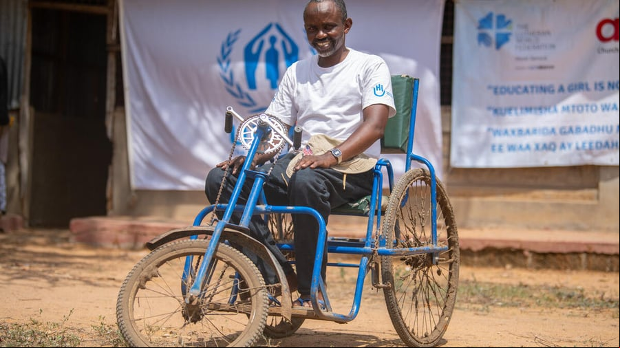 Un hombre sentado en una silla de ruedas hecha con piezas de bicicleta en el campamento de refugiados de Dadaab